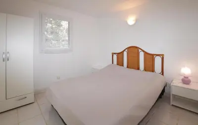 a white bedroom with a bed and a window at Villa Saint Nicolas in Coti-Chiavari