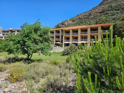 a large building with a mountain in the background at Le Marina in Porto Ota