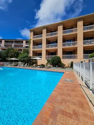 a swimming pool in front of a building at Le Marina in Porto Ota