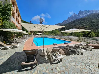 a pool with chairs and umbrellas next to a building at Le Marina in Porto Ota