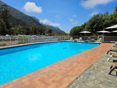 a large blue swimming pool with chairs and umbrellas at Le Marina in Porto Ota