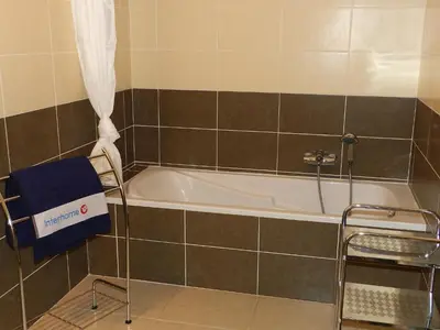 a bath tub in a bathroom with a chair next to it at Apartment Lup - Les terrasses d'Alistro by Interhome in San-Giuliano