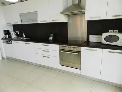 a kitchen with white cabinets and a microwave at Apartment Lup - Les terrasses d'Alistro by Interhome in San-Giuliano