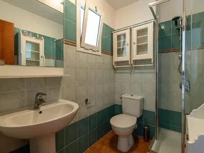 a bathroom with a sink and a toilet and a mirror at Apartment Casa Vecchi by Interhome in Moriani Plage
