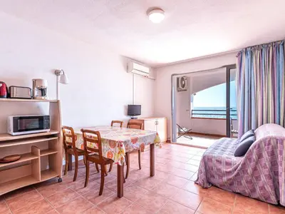 a living room with a dining room table and a couch at Apartment Casa Vecchi by Interhome in Moriani Plage