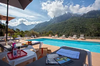 a swimming pool with a view of mountains at Hotel Kalliste in Porto Ota