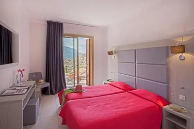 a bedroom with a large red bed and a window at Hotel Kalliste in Porto Ota