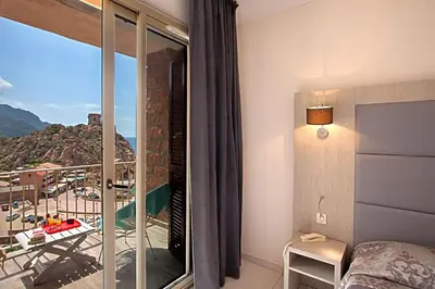 a bedroom with a bed and a balcony with a view at Hotel Kalliste in Porto Ota