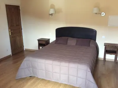 a bedroom with a large bed with two tables at Hotel Restaurant de la Poste in Aullène