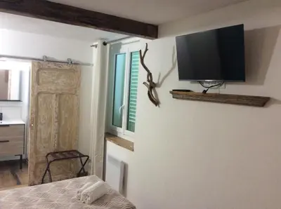 a bedroom with a flat screen tv on a wall at Hotel Restaurant de la Poste in Aullène