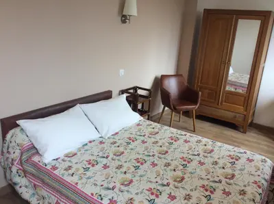 a bedroom with a bed and a chair and a window at Hotel Restaurant de la Poste in Aullène