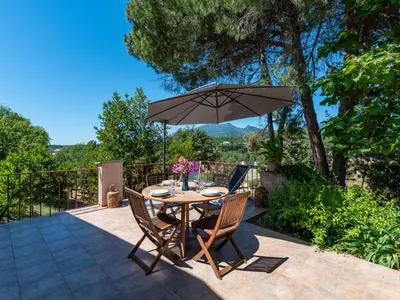 a table and chairs with an umbrella on a patio at Holiday Home Maison Josée by Interhome in Cervione