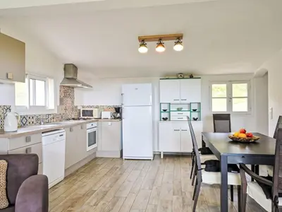 a kitchen with a table and a white refrigerator at Holiday Home Maison Gerard by Interhome in Cervione