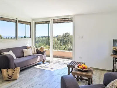 a living room with a couch and some windows at Holiday Home Maison Gerard by Interhome in Cervione