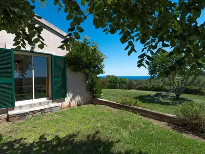 a dining table on the balcony of a house at Holiday Home Maison Christian by Interhome in Cervione