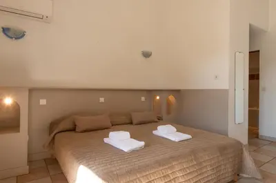 a bedroom with a large bed with two towels on it at Domaine De Caranella in Porto-Vecchio
