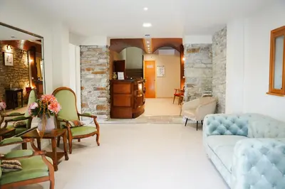 a living room with a couch and two chairs at Hôtel 