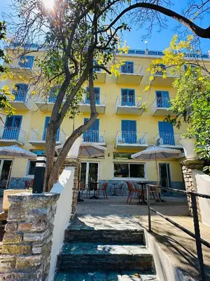 a large yellow building with trees in front of it at Hôtel 