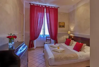 a bedroom with a large bed with red curtains at Mare E Monti - Hôtel de Charme in Feliceto