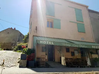 a hotel with tables and chairs in front of a building at Auberge Casa Mathea in Poggio-di-Venaco
