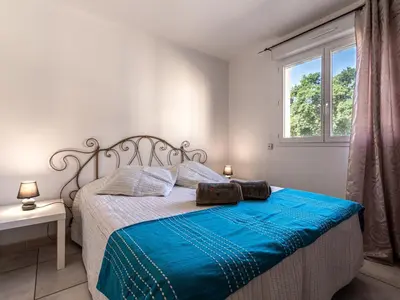 a bedroom with a bed with blue sheets and a window at Villa Gelormini-2 by Interhome in Prunelli-di-Fiumorbo