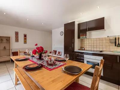 a kitchen with a wooden table with plates and wine glasses at Villa Gelormini-2 by Interhome in Prunelli-di-Fiumorbo