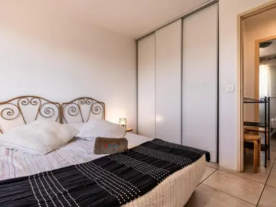 a bedroom with a bed with a black and white blanket at Villa Gelormini-1 by Interhome in Prunelli-di-Fiumorbo