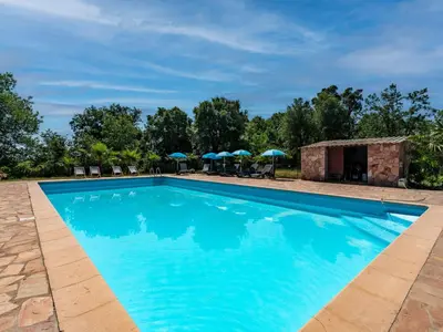 a swimming pool at a resort with umbrellas at Villa Gelormini-1 by Interhome in Prunelli-di-Fiumorbo