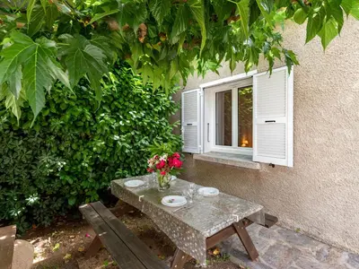 a table with flowers on it next to a window at Holiday Home Dami I-1 by Interhome in Santa-Lucia-di-Moriani