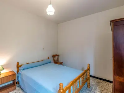 a bedroom with a bed and a table and a chair at Holiday Home Dami I-2 by Interhome in Santa-Lucia-di-Moriani