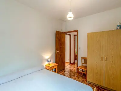 a bedroom with a bed and a wooden cabinet at Holiday Home Dami I-2 by Interhome in Santa-Lucia-di-Moriani