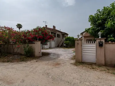 a house with a gate and a driveway with flowers at Holiday Home Dami I-2 by Interhome in Santa-Lucia-di-Moriani