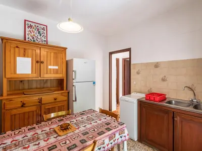 a kitchen with a table and a white refrigerator at Holiday Home Dami I-2 by Interhome in Santa-Lucia-di-Moriani