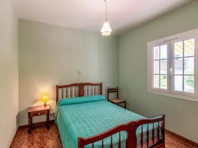 a bedroom with a bed with a green comforter at Holiday Home Dami I-2 by Interhome in Santa-Lucia-di-Moriani