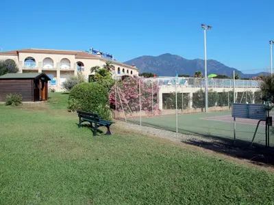 a tennis court with a bench and a tennis racket at Holiday Home Villa Marie-Jo by Interhome in Cervione