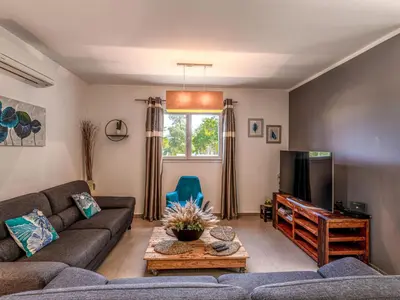 a living room with a couch and a tv at Holiday Home Villa Marie-Jo by Interhome in Cervione