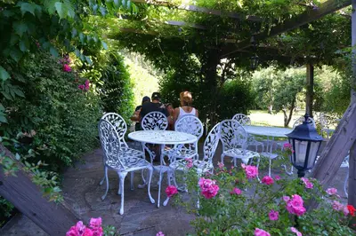 a group of people sitting at tables in a garden at Casa Meridiana in Calacuccia