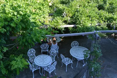 a woman is standing in front of tables and chairs at Casa Meridiana in Calacuccia