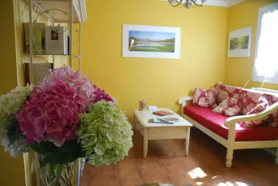 a living room with a couch and a table with flowers at Casa Meridiana in Calacuccia