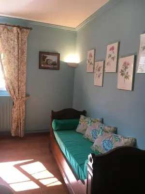 a bedroom with a green bed and a window at Casa Meridiana in Calacuccia