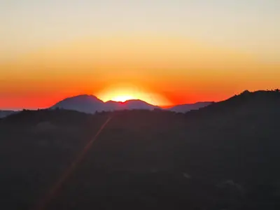 a sunset over mountains with a road in the foreground at Ferme auberge du col de la vaccia in Olivese