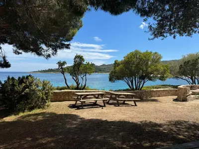 a group of picnic tables in front of the water at Faounzina Village in Favone