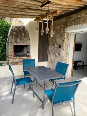 a table and chairs on a patio with a fireplace at La Villa in Favone