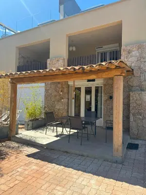 a patio with a table and chairs in front of a house at La Villa in Favone