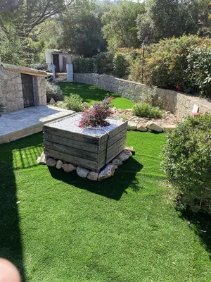 a garden with a flower bed in the grass at La Villa in Favone