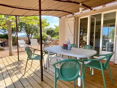 a table and chairs under an umbrella on a deck at Domaine de la Punta in Porto-Vecchio