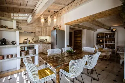 a kitchen with a table and chairs and a refrigerator at U Capu Biancu in Bonifacio