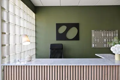 an office with a desk with a chair and green walls at Hôtel de Porticcio in Porticcio