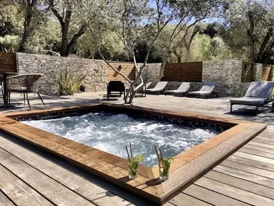 a swimming pool with a wooden deck and a patio at Hôtel E Tre Stelle in Bonifacio