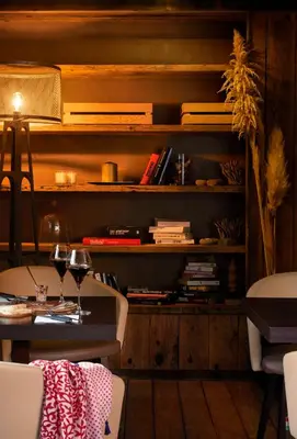 a room with a table and a shelf with books at Hôtel E Tre Stelle in Bonifacio